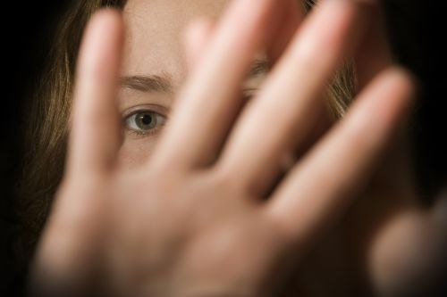 A woman's hands in front of her face. Concept for childhood sexual abuse.