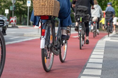 Cyclists cross road on red bike crossing. Visual concept for a personal injury blog discussing cycling safety tips.