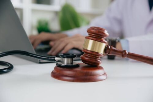 Gavel With medical Stethoscope while doctor using laptop, Concept of personal injury and a Columbus Personal Injury Attorney law blog.